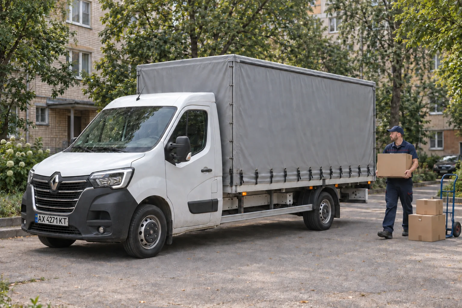 Вантажник NOVAGRUZ біля тентованого Renault Master у Харкові